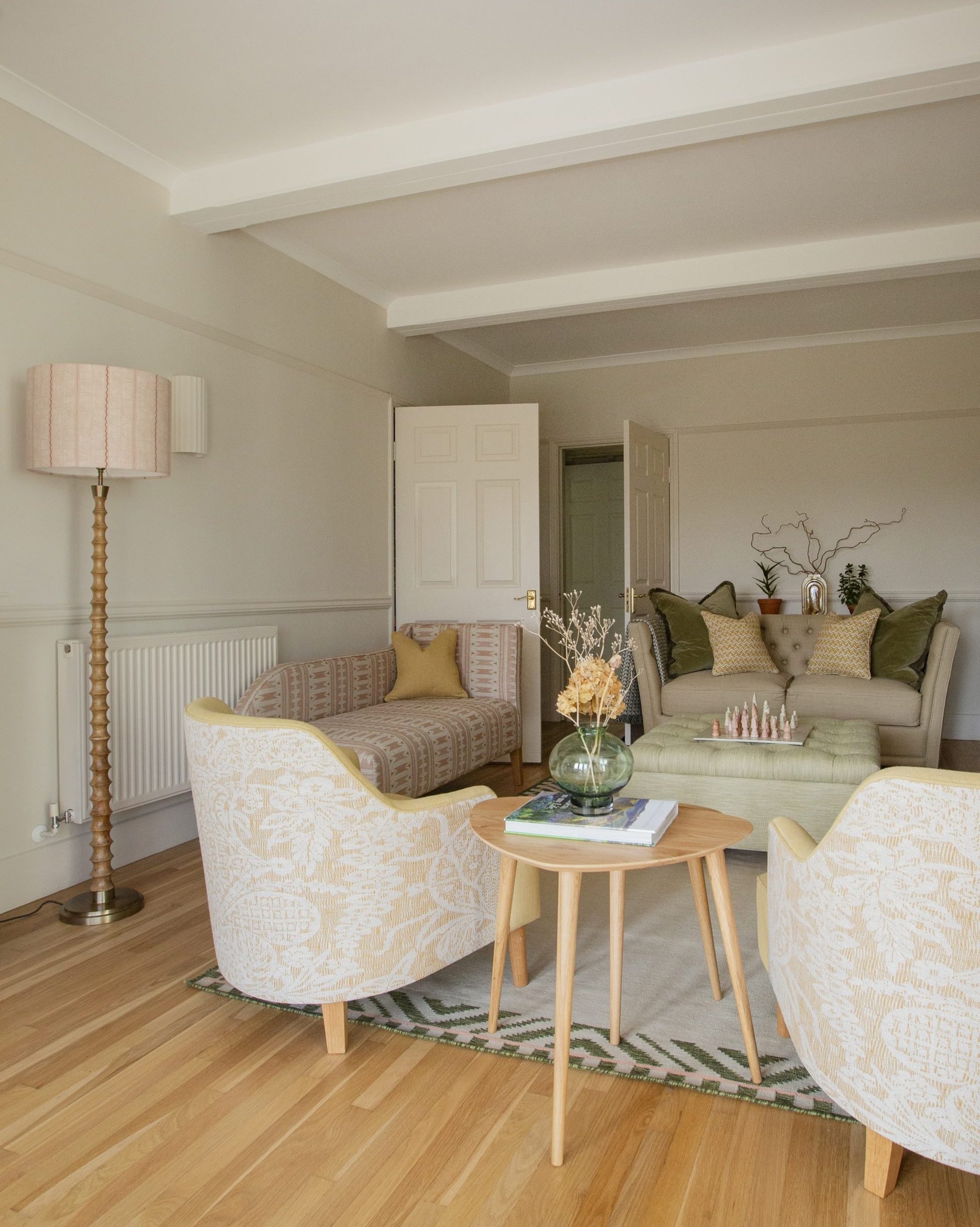 Warm, inviting living room with layered seating and soft green accents