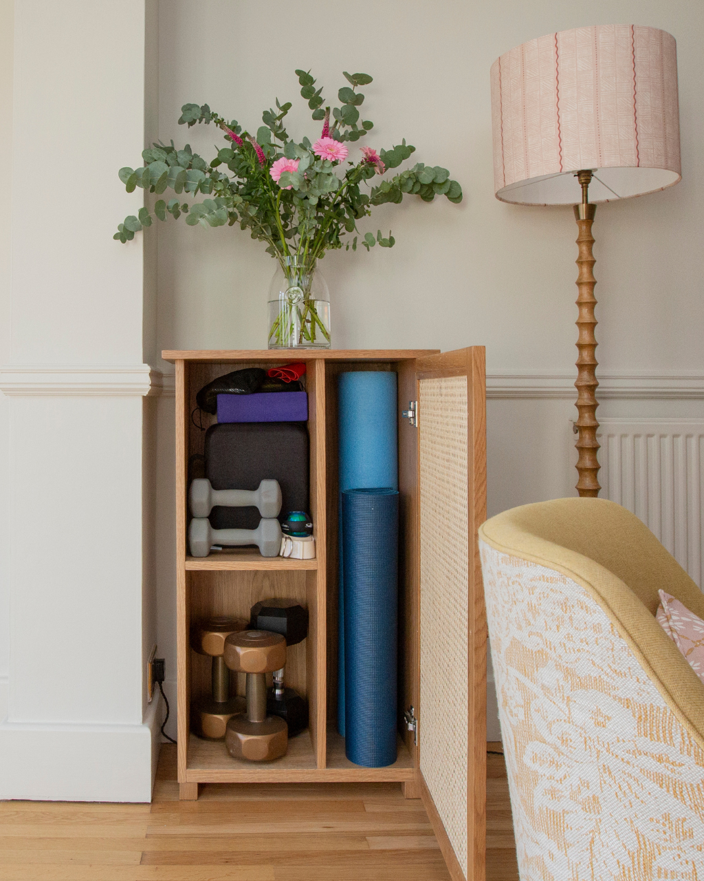 Open bespoke cabinet showing hidden yoga and fitness storage