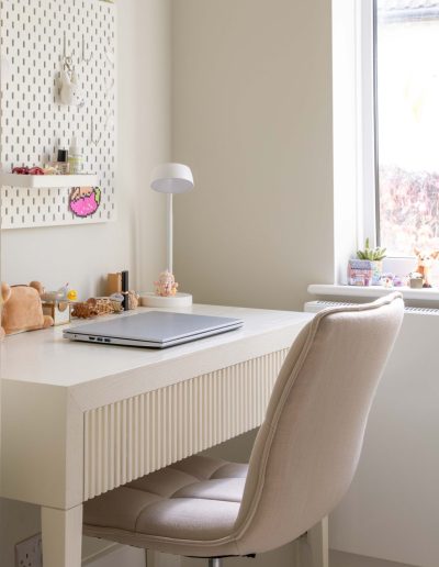 Child's bedroom fluted dressing table with upholstered chair, pegboard and natural light from window, designed by The House Ministry.