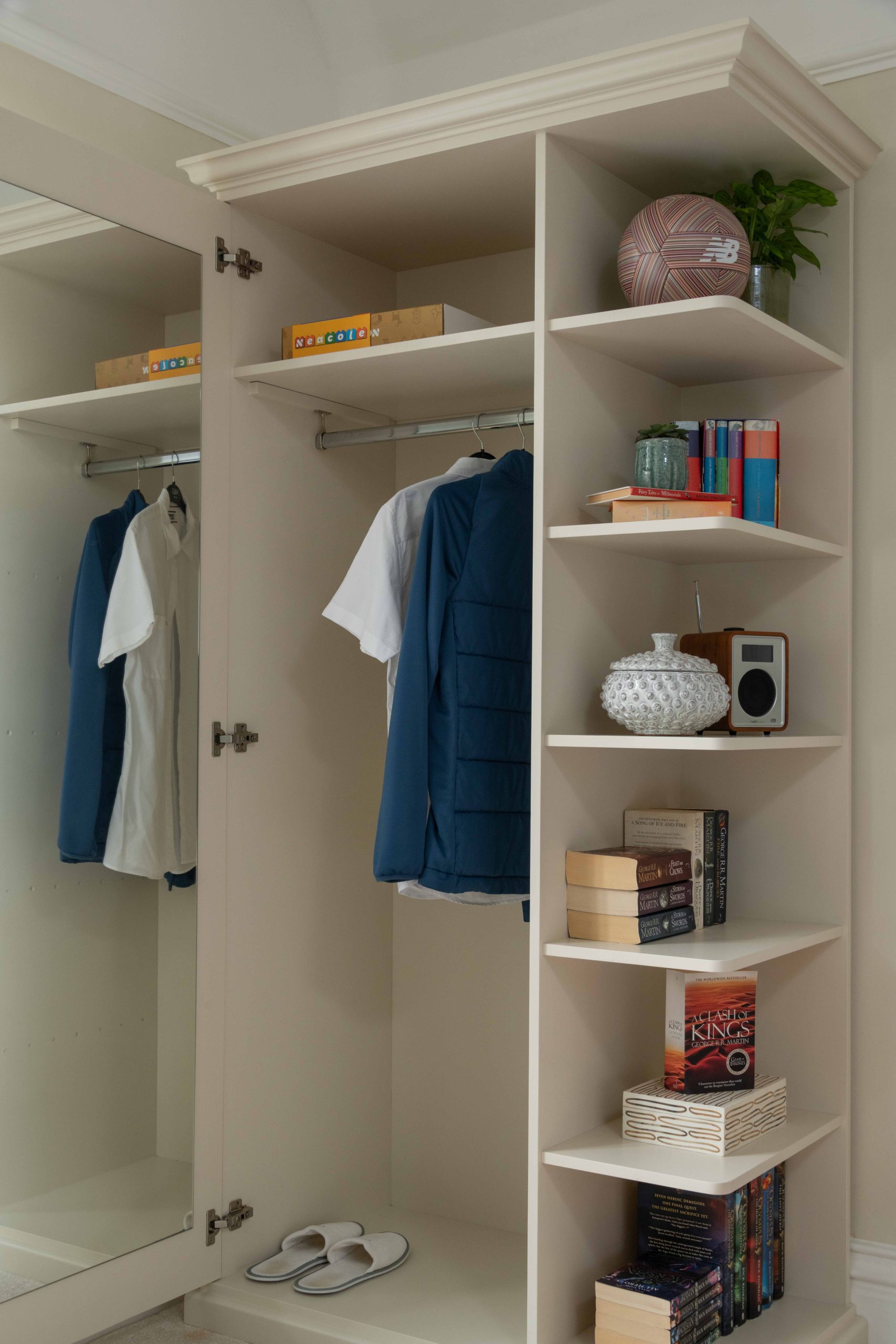 Bespoke Wardrobe Open with Internal Storage and Display Shelving | The House Ministry Bespoke wardrobe open showing internal hanging rail, mirrored door, shelved storage and open display shelving for books and ornaments, designed by The House Ministry.