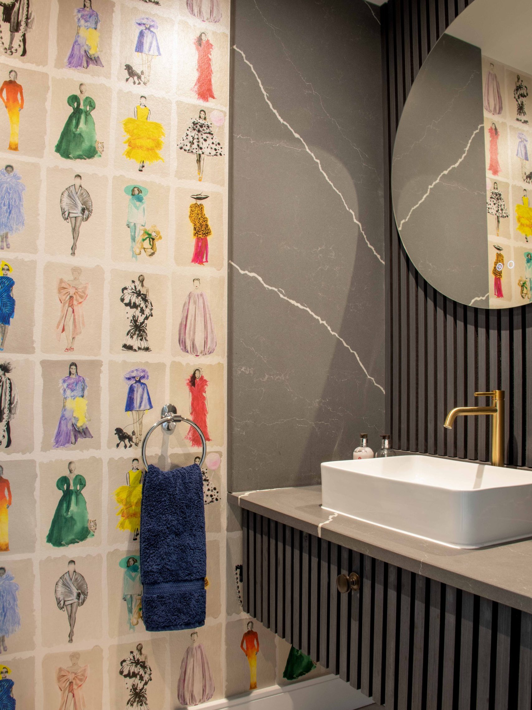 Illustrated Fashion Wallpaper WC | The House Ministry Downstairs WC with illustrated fashion-figure wallpaper from Cole & Son, dark fluted panelling and a round mirror above a sink